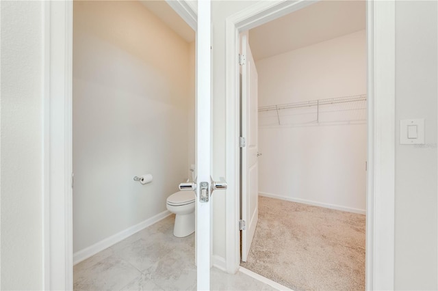 bathroom with toilet and baseboards