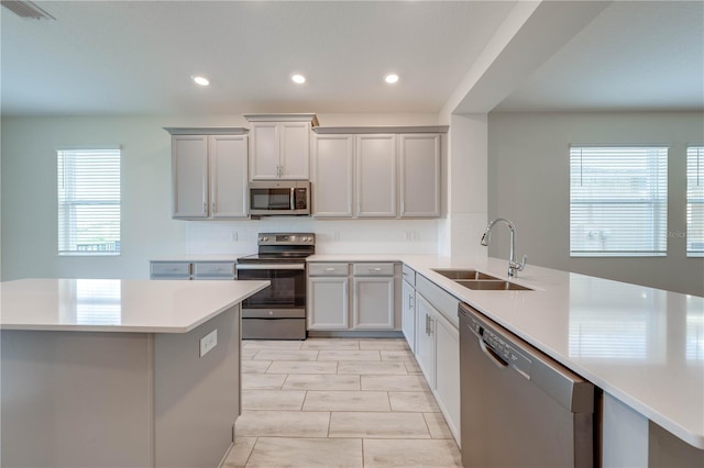 kitchen featuring visible vents, stainless steel appliances, a sink, and light countertops