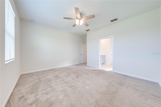 3415 Sagebrush St, Harmony, FL 34773 - unfurnished bedroom with multiple windows, light carpet, and ensuite bath
