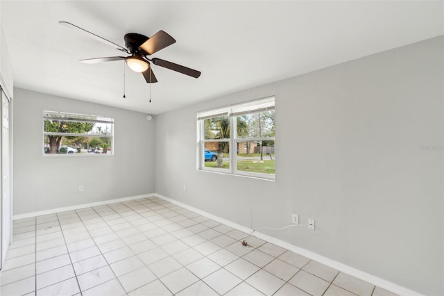 spare room featuring light tile patterned floors, baseboards, and ceiling fan