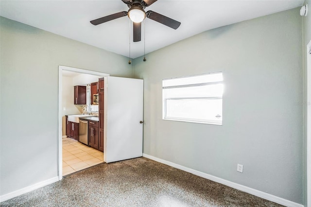 unfurnished bedroom featuring baseboards, ensuite bath, and a ceiling fan