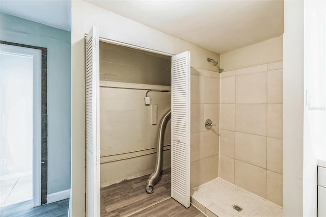 bathroom with wood finished floors and a stall shower