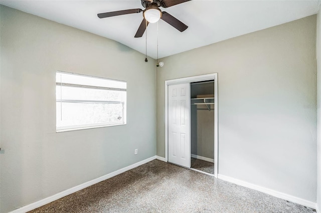 unfurnished bedroom featuring a closet, baseboards, ceiling fan, and speckled floor