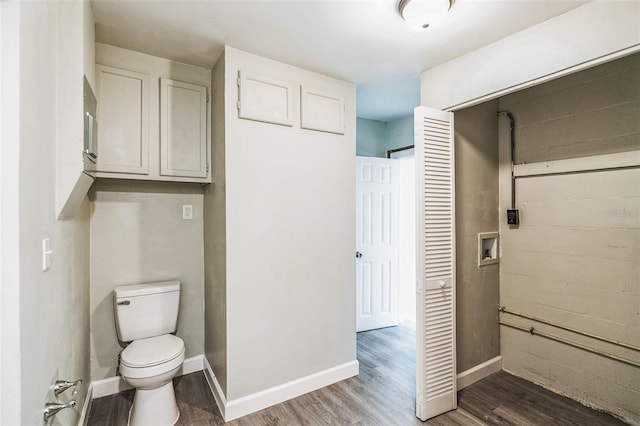 bathroom featuring baseboards, toilet, and wood finished floors