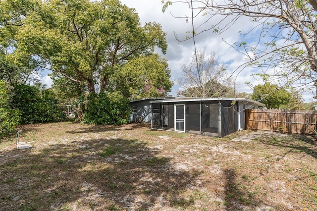 view of yard with a sunroom and fence