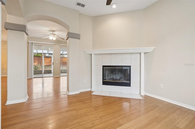 unfurnished living room with visible vents, baseboards, ceiling fan, light wood-style flooring, and a tile fireplace