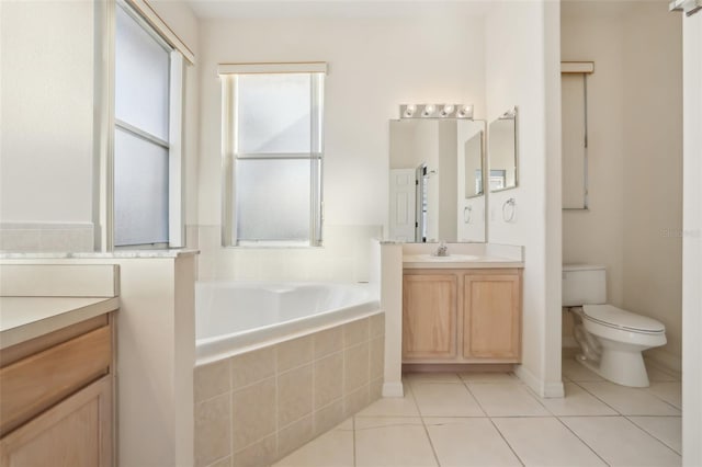 full bath featuring vanity, a garden tub, toilet, and tile patterned flooring