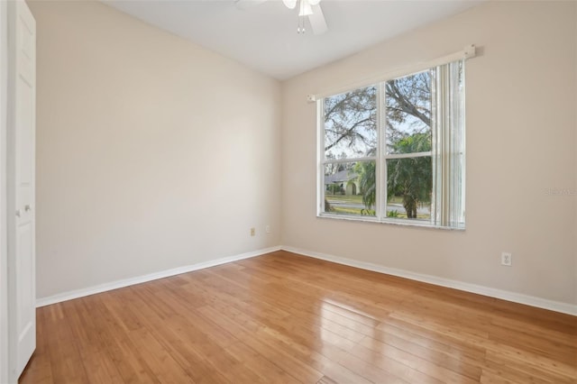 spare room with ceiling fan, light wood-type flooring, and baseboards