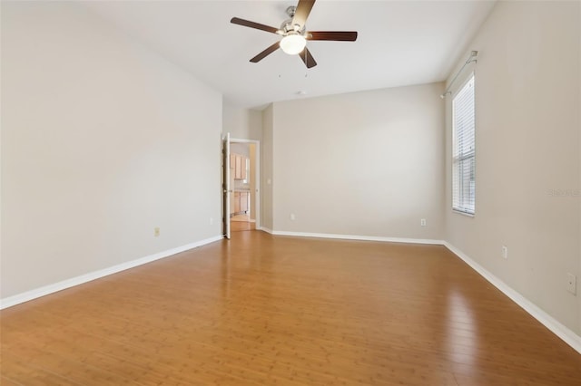 empty room with ceiling fan, baseboards, and light wood-style floors