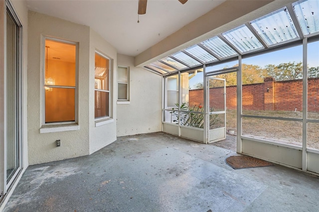 unfurnished sunroom with plenty of natural light and a ceiling fan