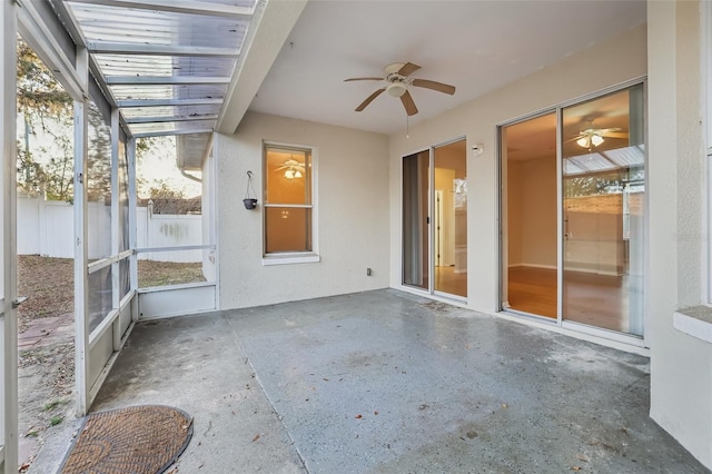 unfurnished sunroom with ceiling fan