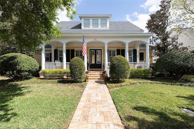 view of front of home featuring a porch, a front yard, french doors, and roof with shingles