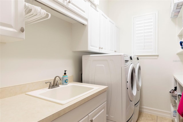 2161 Snow Rd, Orlando, FL 32814 - laundry room with washing machine and dryer, light tile patterned floors, a sink, cabinet space, and baseboards