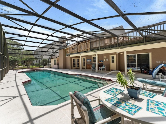 outdoor pool with french doors, a patio area, and a lanai