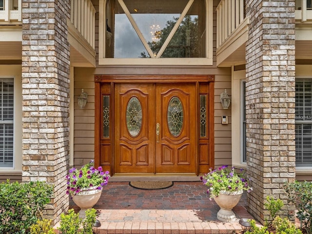 view of exterior entry featuring brick siding