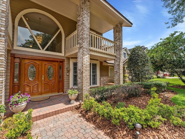 doorway to property with brick siding and a balcony