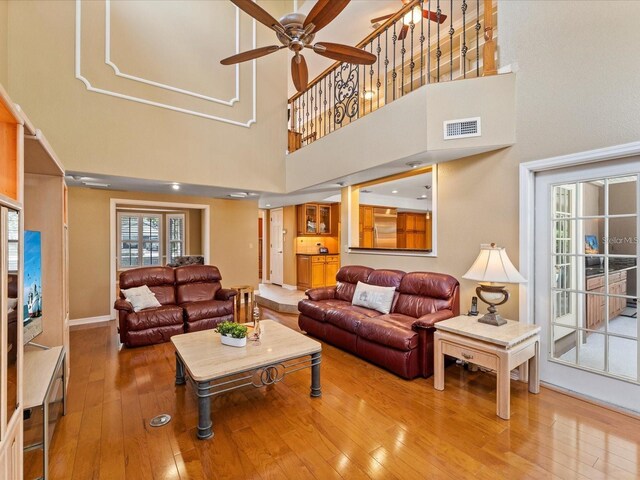 living area featuring hardwood / wood-style floors, visible vents, and a ceiling fan