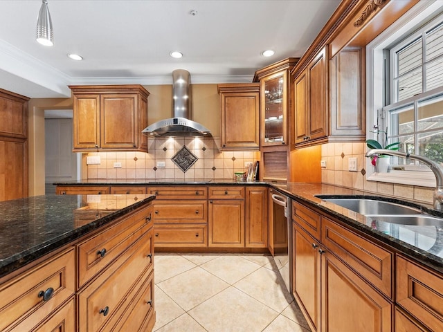 kitchen featuring brown cabinets, a sink, and wall chimney exhaust hood