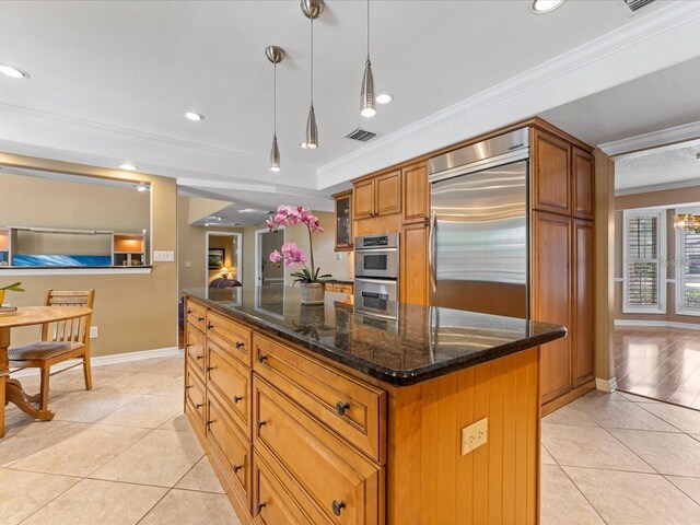 kitchen featuring visible vents, appliances with stainless steel finishes, brown cabinets, and ornamental molding