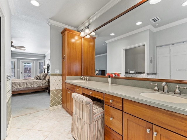 bathroom featuring ensuite bath, visible vents, a sink, and ornamental molding