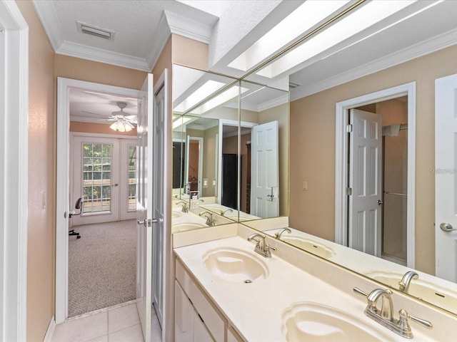 bathroom featuring ornamental molding, a skylight, a sink, and visible vents