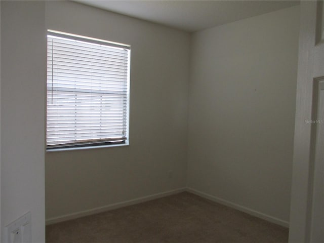 unfurnished room with carpet and baseboards