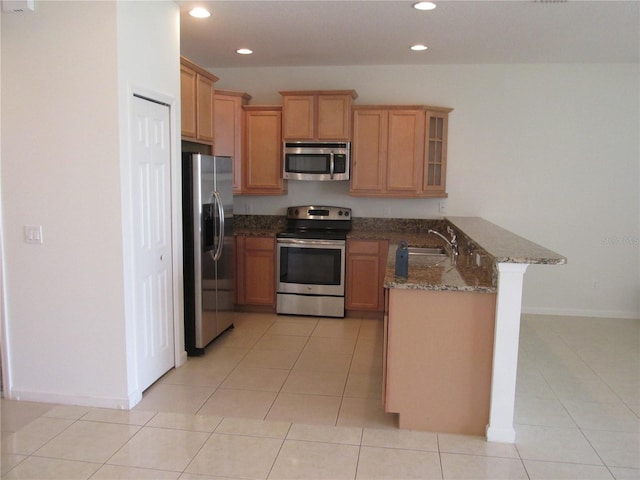 kitchen featuring light tile patterned floors, recessed lighting, a peninsula, appliances with stainless steel finishes, and glass insert cabinets