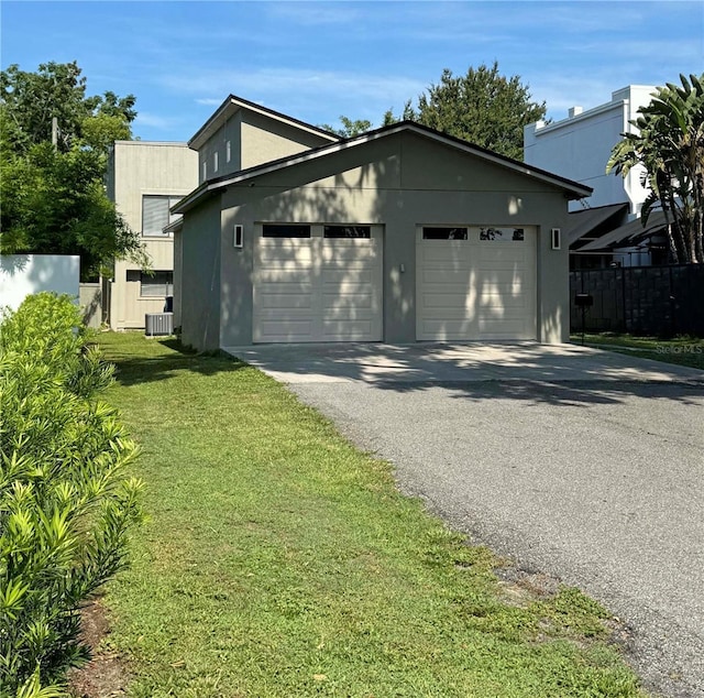 view of front facade with driveway, stucco siding, cooling unit, and fence