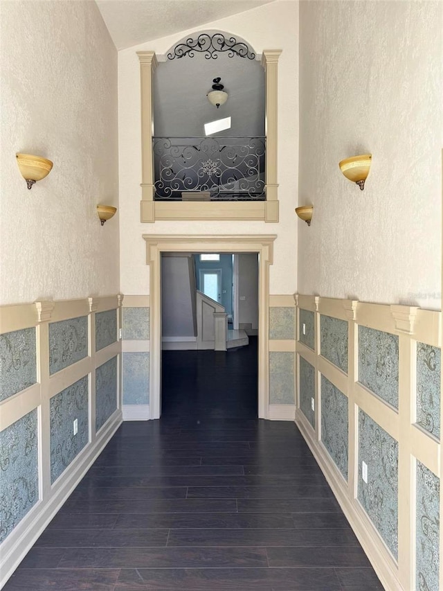 hallway featuring a textured wall and wood finished floors