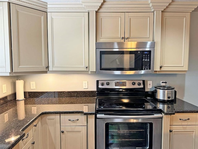kitchen with appliances with stainless steel finishes and dark stone countertops