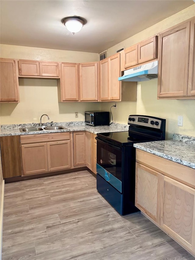 kitchen featuring under cabinet range hood, stainless steel microwave, black range with electric stovetop, and light brown cabinetry