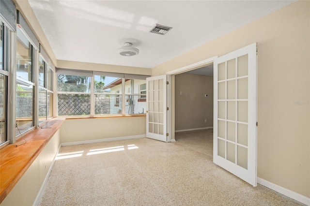 unfurnished sunroom with visible vents and french doors