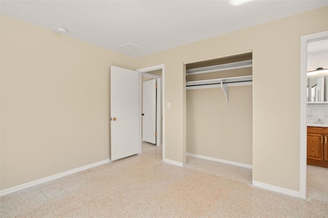 unfurnished bedroom with a closet and baseboards