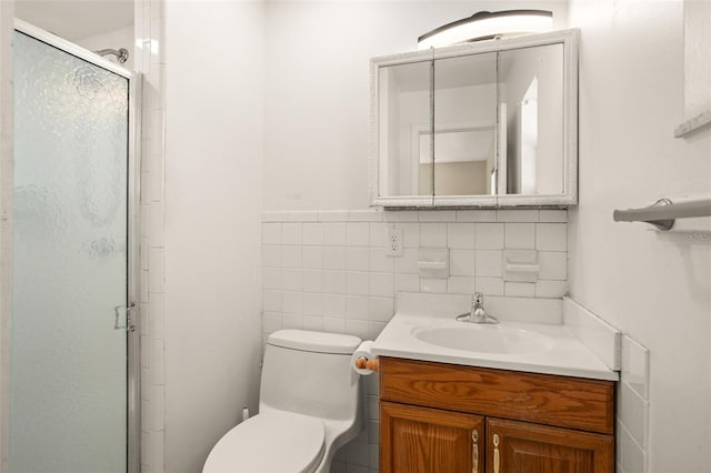 full bathroom featuring a stall shower, toilet, a wainscoted wall, vanity, and tile walls