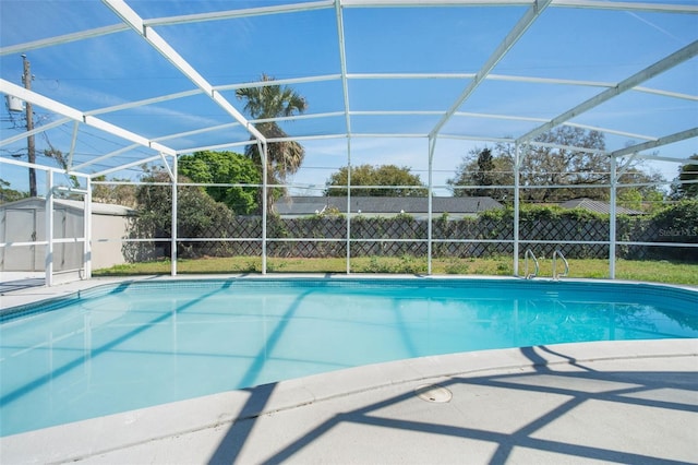 view of pool featuring an outdoor structure, fence, a fenced in pool, and a lanai