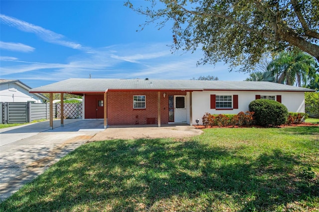 single story home featuring brick siding, fence, driveway, a carport, and a front yard