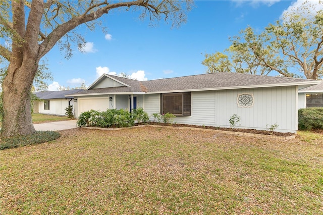 ranch-style home with a garage, a front lawn, and concrete driveway