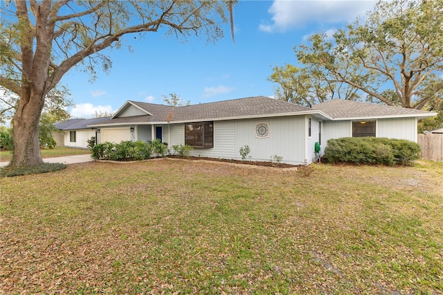 single story home featuring a garage, a front yard, fence, and driveway