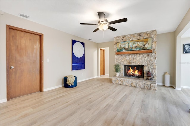 unfurnished living room with a fireplace, wood finished floors, visible vents, and baseboards