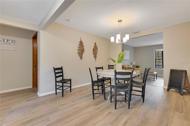 dining room featuring light wood-style floors, visible vents, baseboards, and an inviting chandelier