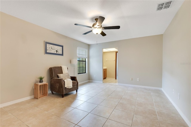 sitting room featuring light tile patterned floors, ceiling fan, visible vents, and baseboards