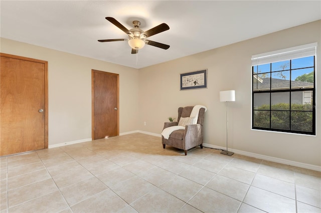 unfurnished room featuring light tile patterned flooring, ceiling fan, and baseboards