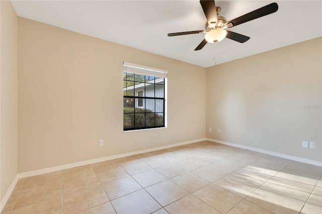 empty room with a ceiling fan, baseboards, and light tile patterned floors