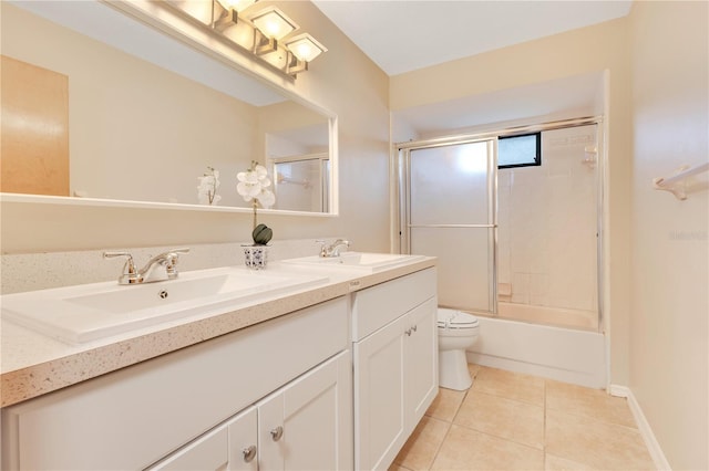 full bathroom featuring toilet, double vanity, a sink, and tile patterned floors