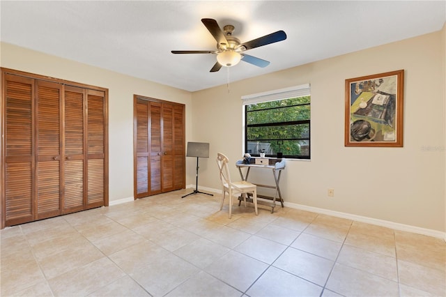 office space featuring ceiling fan, baseboards, and light tile patterned floors