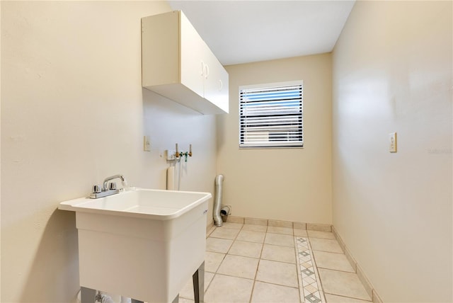 bathroom featuring tile patterned flooring, a sink, and baseboards