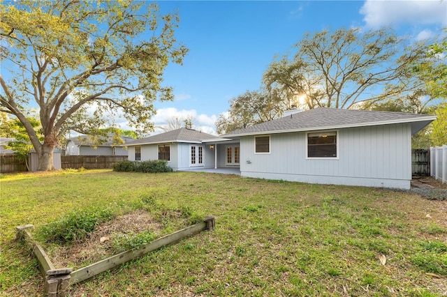 back of house with french doors, a fenced backyard, a lawn, and a chimney