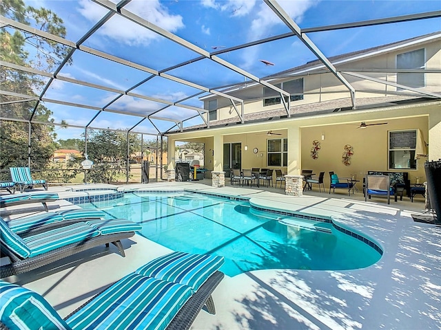 view of pool with a lanai, a pool with connected hot tub, a ceiling fan, and a patio