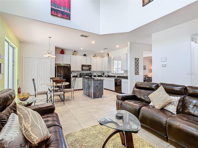 living room featuring recessed lighting, visible vents, a high ceiling, and light tile patterned floors