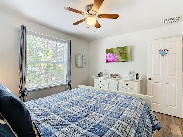 bedroom with light wood-style floors, visible vents, and a ceiling fan